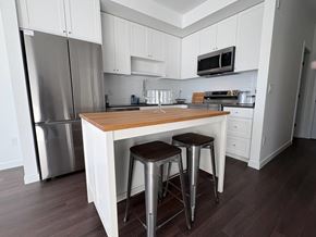 Surrey apartment for rent - A kitchen with white cabinets and a wooden island.