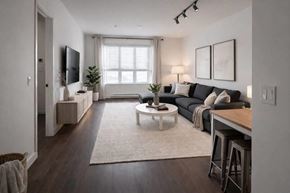 Surrey apartment for rent - A modern living room with a black couch and a white coffee table.