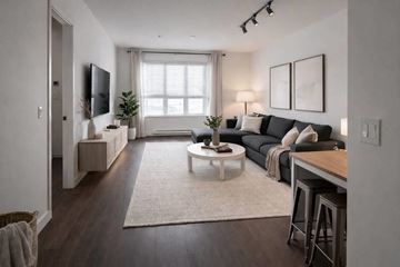 Surrey apartment for rent - A modern living room with a black couch and a white coffee table.