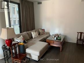 Toronto (Bay Street Corridor) condo for rent - A living room with a couch, chair, and lamp.