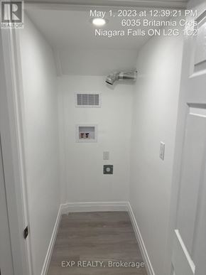 Niagara Falls (Hospital) apartment for rent - A white hallway with a door on the left and a wall-mounted light switch.