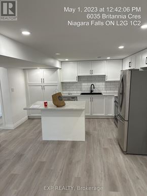 Niagara Falls (Hospital) apartment for rent - A kitchen with a white island and a refrigerator.