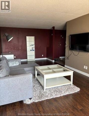 Windsor condo for rent - A living room with a grey couch and a white coffee table.