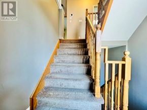 Pickering (Woodlands) townhouse for rent - A staircase with a wooden banister and grey carpeted steps.