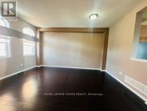 Pickering (Woodlands) townhouse for rent - A spacious room with wooden flooring and a large window.