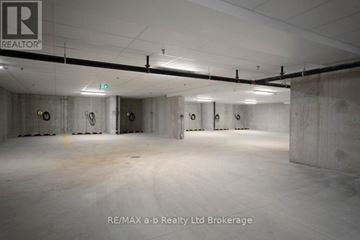 London East (East K) apartment for rent - A large, empty warehouse space with concrete walls and floors, and a logo that reads "RE/MAX a-b Realty Ltd Brokerage" in the bottom right corner.