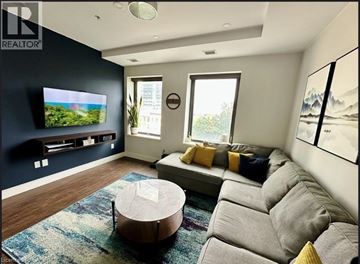 Hamilton condo for rent - A living room with a grey couch and a round coffee table.