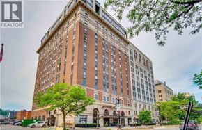 Hamilton condo for rent - A tall building with a sign that says REALTOR on the top left corner.