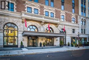 Hamilton condo for rent - A building with a large front entrance and flags hanging above it.