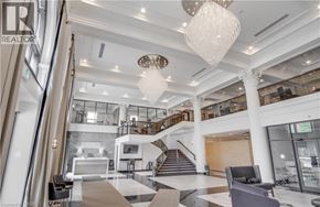 Hamilton condo for rent - A spacious lobby with a staircase and a chandelier.