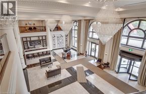 Hamilton condo for rent - A large, open-concept living space with a chandelier and a bar area.