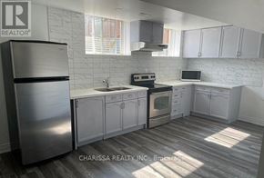 Clarington (Bowmanville) apartment for rent - A kitchen with a refrigerator, stove, and cabinets.