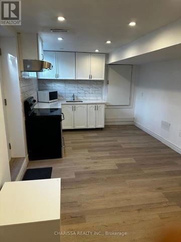 Clarington (Bowmanville) apartment for rent - A kitchen with white cabinets and a marble backsplash.