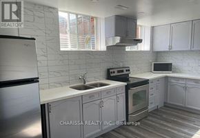 Clarington (Bowmanville) apartment for rent - A kitchen with a refrigerator, sink, stove, and cabinets.