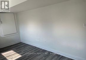 Clarington (Bowmanville) apartment for rent - A room with a wooden floor and white walls, with a door on the left and a light switch on the wall.