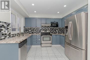 Mississauga (Churchill Meadows) townhouse for rent - A kitchen with a stainless steel refrigerator and a checkered backsplash.