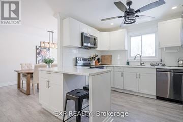Cobourg apartment for rent - A kitchen with white cabinets and a wooden table.