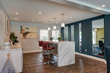 Houston apartment for rent - A modern kitchen with a white island and red chairs.