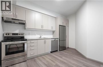 Hamilton apartment for rent - A modern kitchen with stainless steel appliances and white cabinets.