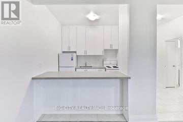 Toronto (St. Andrew-Windfields) condo for rent - A white kitchen with a countertop and cabinets.