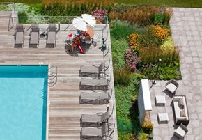 Boston apartment for rent - a man with an umbrella sitting on a deck next to a pool