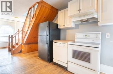 Brantford apartment for rent - A kitchen with a staircase and a refrigerator.