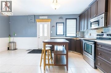 Brantford apartment for rent - A kitchen with a table and chairs in front of a window.