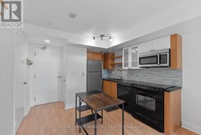 Toronto (Waterfront Communities) condo for rent - A kitchen with a table and a microwave oven.