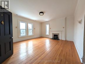 Prince Edward County (Picton Ward) fourplex for rent - A room with a fireplace and a door on the left side.
