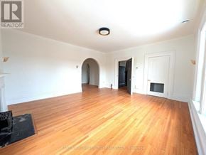 Prince Edward County (Picton Ward) fourplex for rent - A spacious room with wooden floors and white walls.