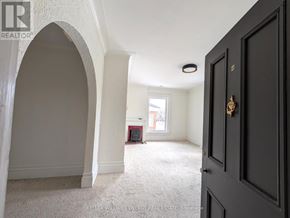Prince Edward County (Picton Ward) fourplex for rent - A room with a carpeted floor and a large arched doorway.