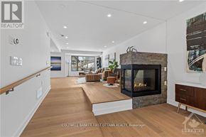 Ottawa apartment for rent - A modern living room with a stone fireplace and a large window.