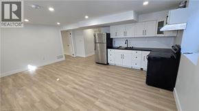 London apartment for rent - A kitchen with white cabinets and black countertops.