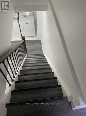 Ajax (South East) apartment for rent - A staircase with a black handrail and wooden steps.