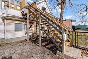 Thorold (Thorold Downtown) duplex for rent - A wooden staircase with a metal railing leads up to a balcony.