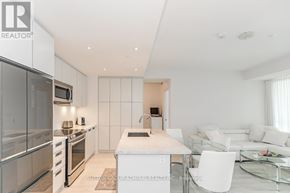 Innisfil condo for rent - A modern kitchen with stainless steel appliances and a glass table.