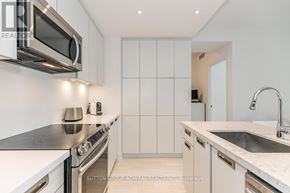 Innisfil condo for rent - A modern kitchen with white cabinets and stainless steel appliances.