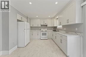 Windsor apartment for rent - A white kitchen with a refrigerator, sink, and cabinets.
