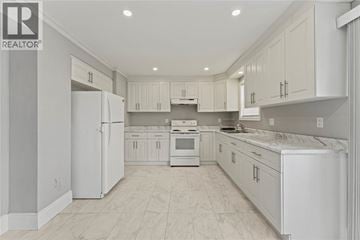 Windsor apartment for rent - A white kitchen with a refrigerator, sink, and cabinets.