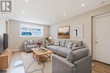 Toronto (East York) multi-family for rent - A living room with a grey couch and a wooden coffee table.