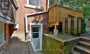 Toronto (The Beaches) apartment for rent - A wooden structure with a door is in front of a brick building.