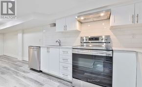 Toronto (The Beaches) apartment for rent - A modern kitchen with white cabinets and stainless steel appliances.