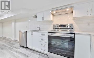 Toronto (The Beaches) apartment for rent - A modern kitchen with white cabinets and stainless steel appliances.