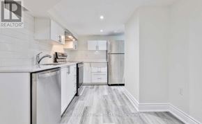 Toronto (The Beaches) apartment for rent - A modern kitchen with white cabinets and appliances.