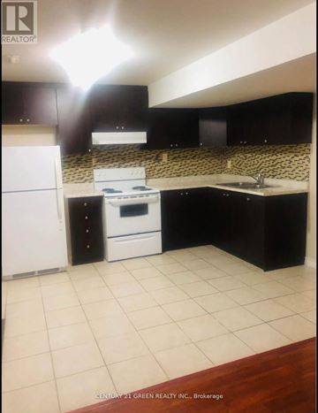 Mississauga (East Credit) apartment for rent - A kitchen with black cabinets and a white refrigerator.