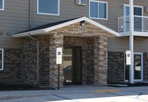 Moorhead apartment for rent - a brick building with a door and street signs