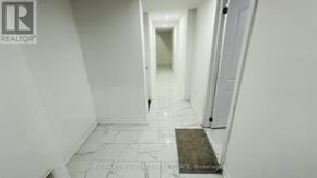 Kitchener apartment for rent - A hallway with a rug on the floor and a door on the right.