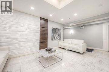 Guelph condo for rent - A modern living room with a white sofa and a glass coffee table.