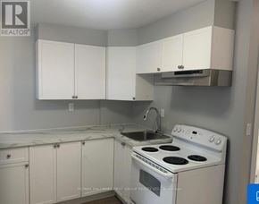 Oshawa (Lakeview) multi-family for rent - A kitchen with white cabinets and a white stove top oven.