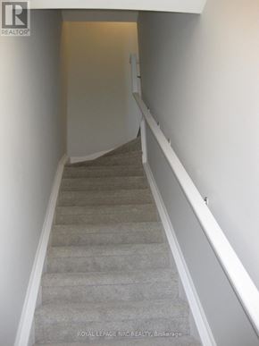 Niagara Falls (Morrison) townhouse for rent - A staircase with a carpeted runner and white walls.